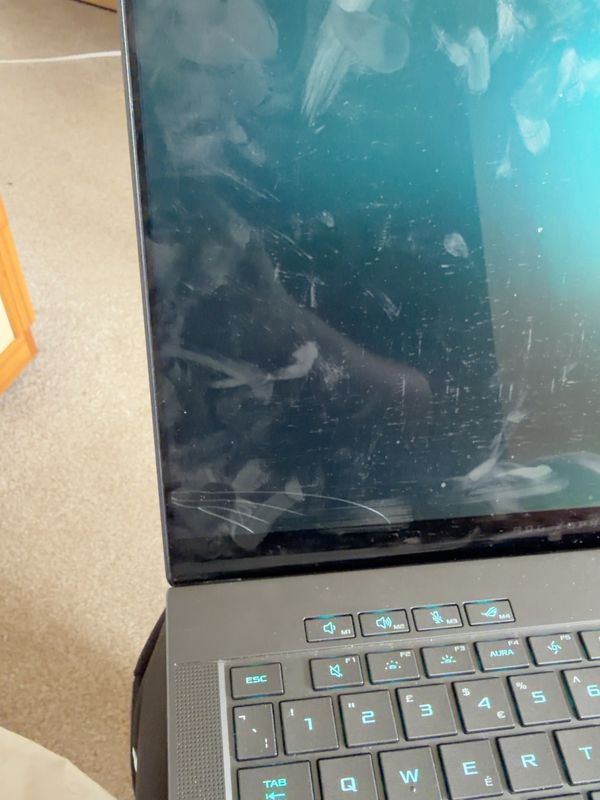 Asus ROG Zephyrus laptop with a cracked screen, shown closed at an angle